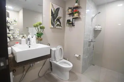 a bathroom with a toilet and a sink and a shower at Kuya Awens Staycation in Manila
