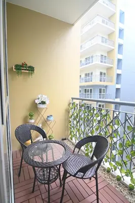 a patio with two chairs and a table on a balcony at Kuya Awens Staycation in Manila