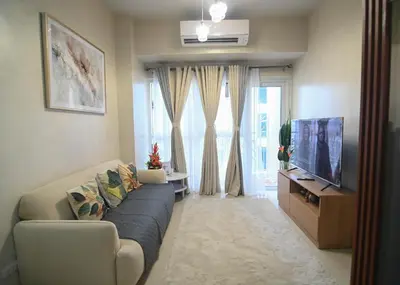 a living room with a couch and a tv at Kuya Awens Staycation in Manila