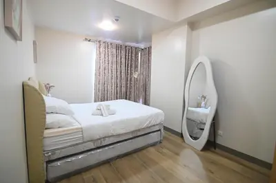a bedroom with a bed with a mirror and a sink at Kuya Awens Staycation in Manila