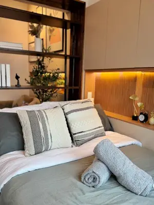 a bed with a pile of pillows on it at 1-BR condo unit near Rockwell, Poblacion in Manila