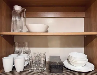 a shelf with dishes and glasses on it at Charming Unit at Smdc Sun Residences in Manila