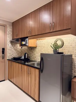 a kitchen with wooden cabinets and a stainless steel refrigerator at Charming Unit at Smdc Sun Residences in Manila