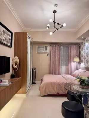 a bedroom with a bed and a glass table at Charming Unit at Smdc Sun Residences in Manila