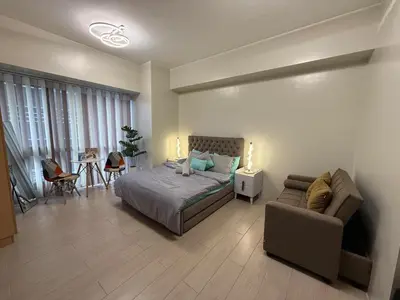 a bedroom with a bed and a couch and a table at Cozy Condo Unit Near NAIA Terminal 3 in Manila