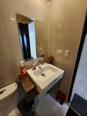 a bathroom with a sink and a toilet and a mirror at Cozy Condo Unit Near NAIA Terminal 3 in Manila