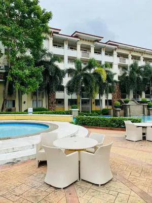 a building with a table and chairs and a pool at Your Comfort Zone Staycation3 in Manila