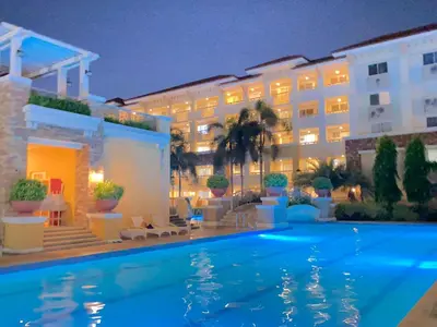 a hotel with a swimming pool at night at Your Comfort Zone Staycation3 in Manila