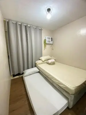 two beds in a small room with a window at Your Comfort Zone Staycation3 in Manila