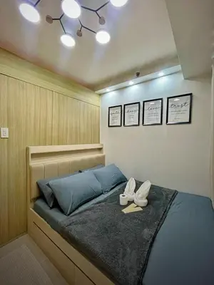 a bedroom with a bed with two shoes on it at Shore 1 Residences - ÜniQa Suite - MOA Area in Manila