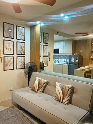 a couch with pillows on it in a living room at Shore 1 Residences - ÜniQa Suite - MOA Area in Manila