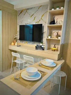 a kitchen with a table with chairs and a television at Shore 1 Residences - ÜniQa Suite - MOA Area in Manila