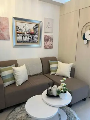 a living room with a couch and a table at South Residences Tower 4, Las Pinas in Manila
