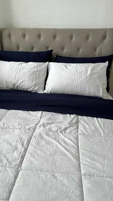 a large bed with white sheets and pillows at South Residences Tower 4, Las Pinas in Manila