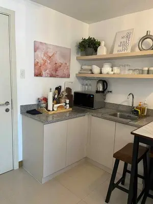 a kitchen with a counter with a sink and a microwave at South Residences Tower 4, Las Pinas in Manila