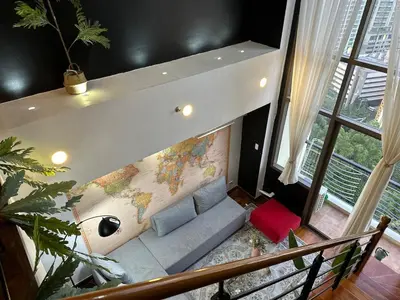a living room with a couch with a map on the wall at Stylish 100 SQM 3BR Loft Near Greenbelt Makati in Manila