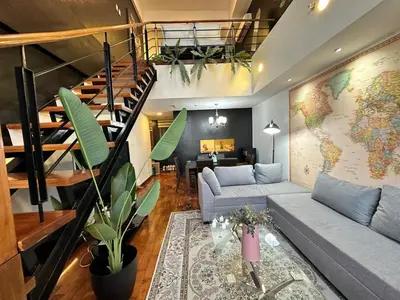 a living room with a couch and a staircase at Stylish 100 SQM 3BR Loft Near Greenbelt Makati in Manila