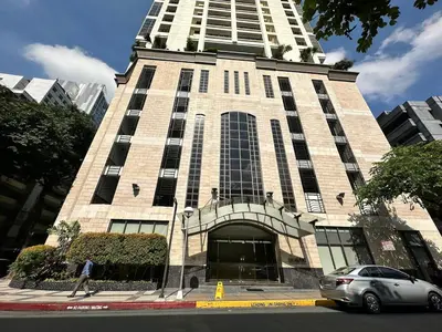 a car parked in front of a tall building at Stylish 100 SQM 3BR Loft Near Greenbelt Makati in Manila