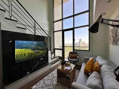 a living room with a couch and a flat screen tv at Huge 100-SQM 3BR Loft near Greenbelt Makati in Manila