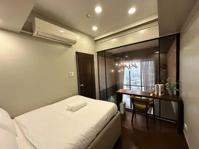 a small bedroom with a bed and a desk at 100 SQM 3BR in Central Makati Greenbelt Area in Manila