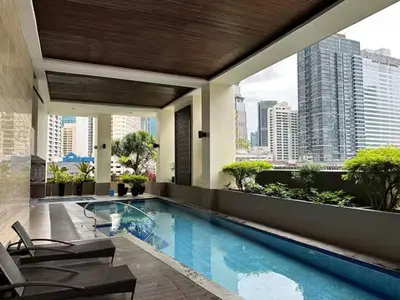 a hotel swimming pool with a view of a city at 100 SQM 3BR in Central Makati Greenbelt Area in Manila