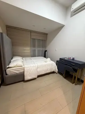 a bedroom with a bed with a desk and a bed sidx sidx sidx at Executive Suites 4 Bedroom Condo Uptown Parksuites Bgc in Manila