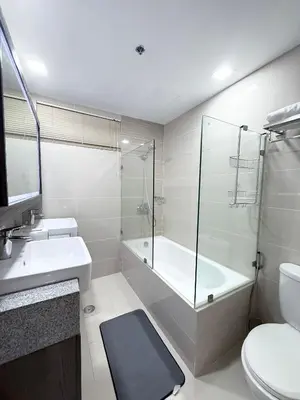a bathroom with a shower and a sink and a toilet at Executive Suites 4 Bedroom Condo Uptown Parksuites Bgc in Manila