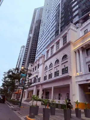 a white building on a street with tall buildings at Executive Suites 4 Bedroom Condo Uptown Parksuites Bgc in Manila