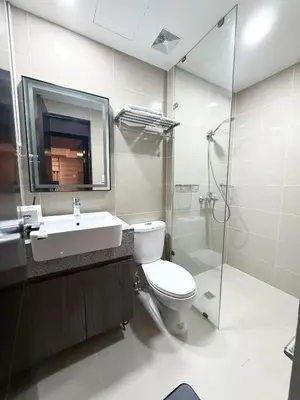 a bathroom with a toilet and a sink and a shower at Executive Suites 4 Bedroom Condo Uptown Parksuites Bgc in Manila