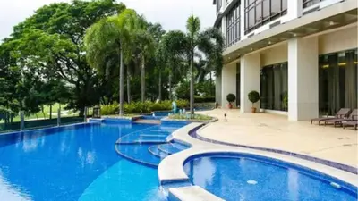 a swimming pool in front of a building at Executive Suites Bellagio Golf View Residences in Manila