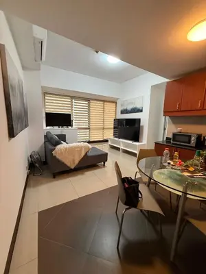 a living room with a table and a couch at Executive Suites Bellagio Golf View Residences in Manila