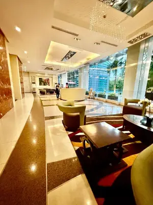 a lobby with a table and chairs in a building at Executive Suites Bellagio Golf View Residences in Manila