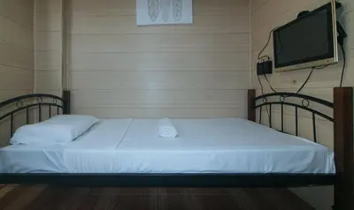 a bedroom with a bed with a flat screen tv at Maine Residences Leveriza by RedDoorz in Manila