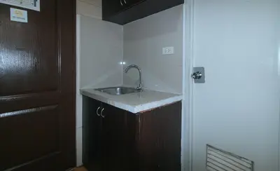 a bathroom with a sink and a door at Maine Residences Leveriza by RedDoorz in Manila
