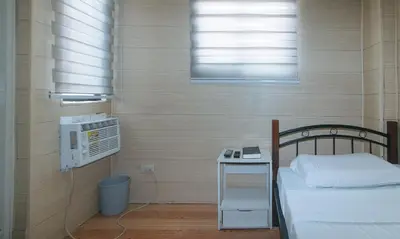 a small bedroom with a bed and a window at Maine Residences Leveriza by RedDoorz in Manila