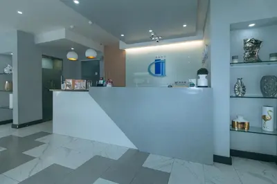 a lobby with a large white counter in a building at Maine Residences Leveriza by RedDoorz in Manila