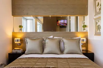 a bedroom with a large bed with a large headboard at Luxurious Studio in McKinley Hill with City View in Manila