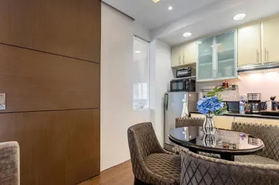 a kitchen and dining room with a table and chairs at Luxurious Studio in McKinley Hill with City View in Manila