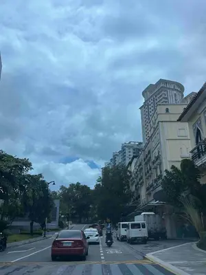 a city street with cars and a building with vehicles at Luxurious Studio in McKinley Hill with City View in Manila