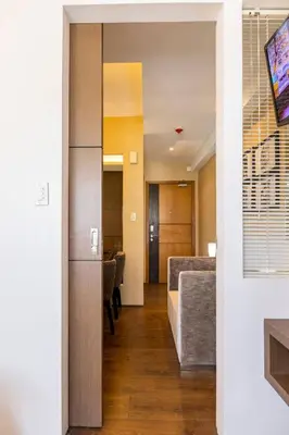 a room with a hallway with chairs and a table at Luxurious Studio in McKinley Hill with City View in Manila