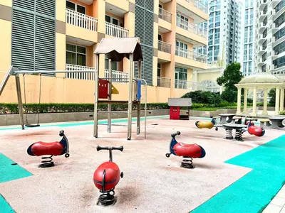 a playground with red play equipment in front of a building at PREMIUM 1BR Venice Canal Mall, Pool, Gym, Sauna & 5G Wi-Fi, Ste 16 in Manila