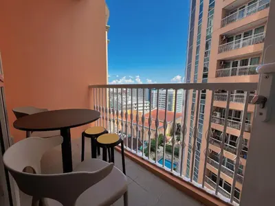 a balcony with a table and chairs and a view of a building at PREMIUM 1BR Venice Canal Mall, Pool, Gym, Sauna & 5G Wi-Fi, Ste 16 in Manila