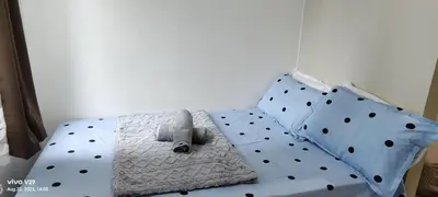 a bed with polka dot sheets and pillows at Graxia staycation in Manila