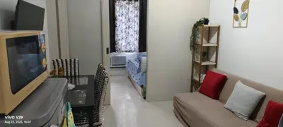 a living room with a couch and a flat screen tv at Graxia staycation in Manila