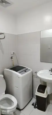 a white bathroom with a toilet and a sink at Graxia staycation in Manila