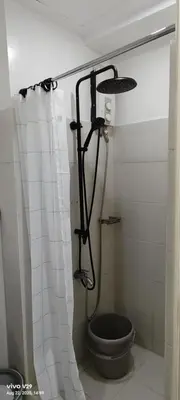 a bathroom with a shower with a toilet in it at Graxia staycation in Manila