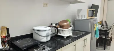 a kitchen counter with a coffee maker and a microwave at Graxia staycation in Manila