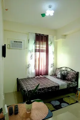 a bedroom with a bed with a window and a table at Cozy Place to Stay in Manila
