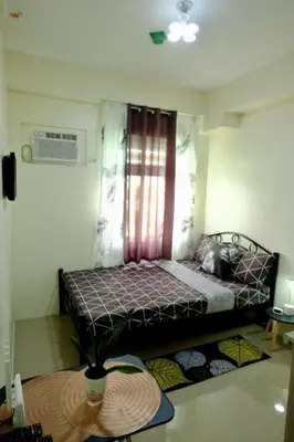 a small bedroom with a bed with a window at Cozy Place to Stay in Manila