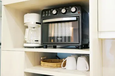 a microwave oven on a shelf in a kitchen at Breathtaking Eastwood City View, 3min walk to Malls, with Washer in Manila